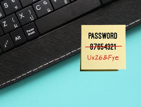 Keyboard on blue background with very weak and easy to guess password written on note - replaced to strong and more secure password