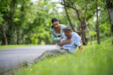 Fototapeta premium A daughter helping her father, old elderly sick senior Asian man got heart attack at park. Health problem. Retired old man chest pain outdoor. Life and insurance concept.