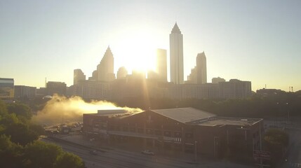 City skyline silhouetted at sunrise with buildings and sunlight