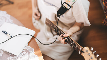 Fototapeta premium Focus hand of woman on electric guitar chord