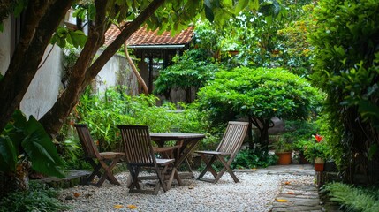 Obraz premium Charming Tropical Retreat: Rustic Wooden Chairs and Table Surrounded by Lush Greenery in Asian Backyard Oasis
