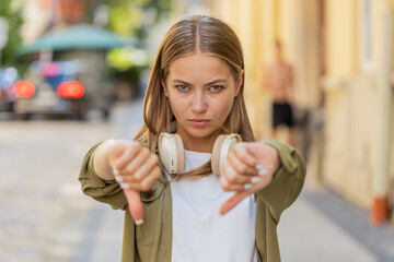 Dislike. Upset Caucasian young woman showing thumb down sign gesture, expressing discontent...