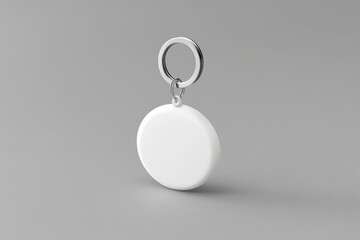 Gray background featuring a white round keychain, sleek and modern.