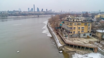An aerial view shows a building near a river and skyline