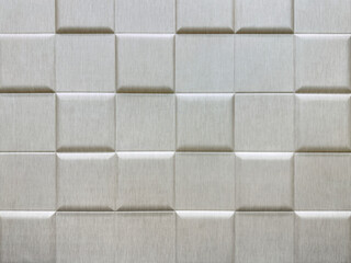 Close up of 3d wall panel in square checkerboard or checkered pattern, in bright glossy silver color. 3D beveled checkered shape used for wall sound insulation. Seamless background texture