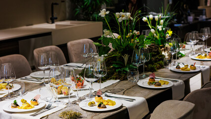 Luxurious dining table setup featuring gourmet appetizers, elegant glassware, floral centerpiece