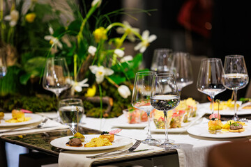 Luxurious dining table setup featuring gourmet appetizers, elegant glassware, floral centerpiece