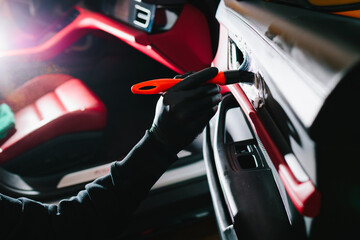 Car detailer cleans the auto door with foam brush and detergent. Process of removing dust and dirt...
