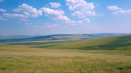 A beautiful daytime landscape of rolling green hills and a blue sky