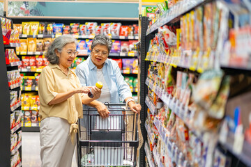 Happy Asian senior woman shopping at supermarket. Healthy elderly women friends enjoy urban...
