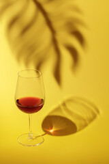 Glass of red wine on a yellow background.