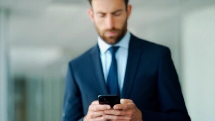 4K video of focused businessman in formal suit using smartphone in modern office hallway, checking emails or texting, symbolizing communication, productivity, and digital business