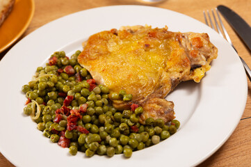 Delicious crispy chicken with peas as a side dish on a plate