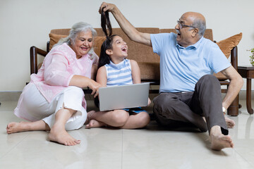 Indian grandparents with Grand daughter playing together ,Grandparent and Grand child using laptop