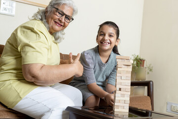 Obraz premium Little grandchild and grandmother playing together ,Retired life