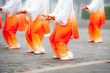 In the foggy morning at the park square, people engage in Tai Chi fitness exercises