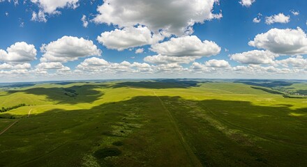 Obraz premium A large, open field with a blue sky and clouds