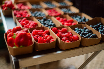 Freshly Packed Strawberries, Raspberries, and Blueberries on a Market Table