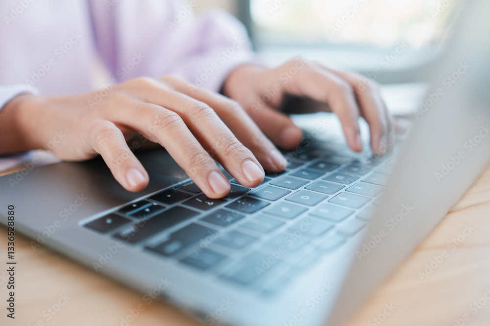 Poster hands typing on a laptop keyboard in a bright workspace, symbolizing modern technology and productiv