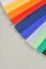 Obraz premium A close-up, angled shot of colorful crepe paper sheets arranged in a diagonal pattern, showcasing their vibrant hues and delicate texture against a neutral background