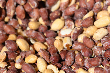 Vibrant mix of assorted peanuts displayed under the bright sunlight in a rustic market setting