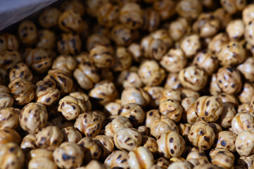Roasted chickpeas glisten under warm light in a bustling market on a vibrant afternoon