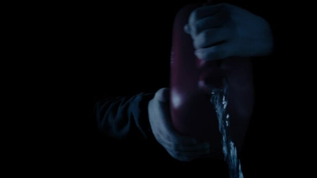 Man Pours Gasoline On Floor In The Dark