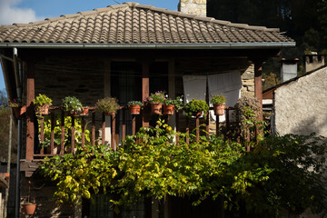 Casa rústica con jardín de flores y cerca de madera.