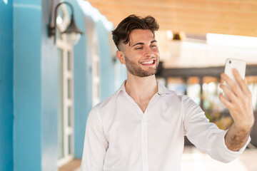 Fototapeta premium Young handsome man making a selfie with mobile phone
