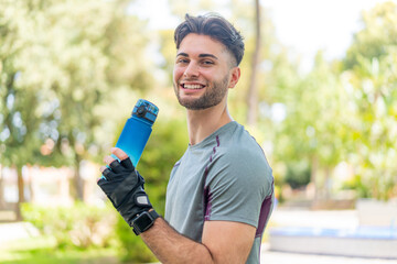 Young handsome man doing sport with a bottle of water