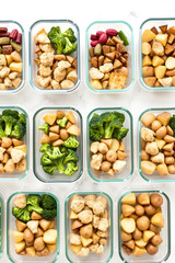 Multiple meal prep containers are filled with a variety of healthy food options, including chicken, broccoli, and potatoes, promoting a balanced diet and convenient meal planning.