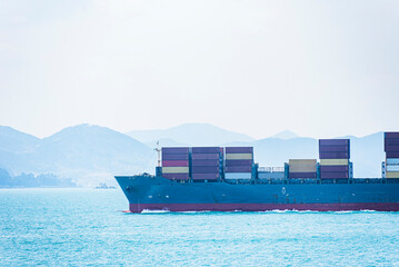 Obraz premium Busan, South Korea - cargo container ship sailing out of the sea port near the Korean coast.