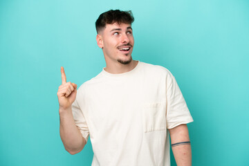 Young caucasian handsome man isolated on blue background intending to realizes the solution while...