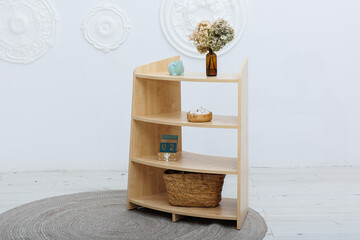 There is a wooden shelf that holds a piggy bank and a basket on it