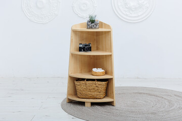 A wooden shelf that features a decorative basket on the bottom shelf