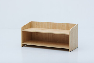 A wooden shelf that features two levels, placed on a white surface