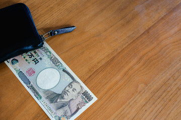 旧一万円札と黒い財布、家計管理のイメージ