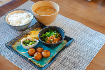 納豆と焼き鳥の和朝食が並ぶ食卓