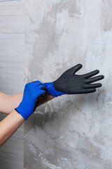 A person is carefully putting on a clean pair of blue gloves