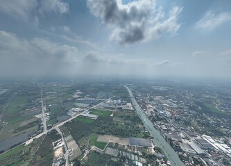 The River's Embrace: An Aerial Glimpse of little town Urban Heart. This drone photograph captures a wide aerial view of Nakhon Pathom, Thailand, with a focus on the river that flows through town