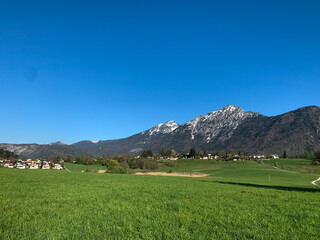 Obraz premium Wide green meadow with a small village in the foreground