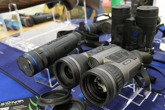 Modern Lithuanian binocular with termovision and laser rangefinder Pulsar Merger LRF XT50 displayed next to monocular and other scopes on Hunting expo in Nitra, Slovakia, march 2025.  