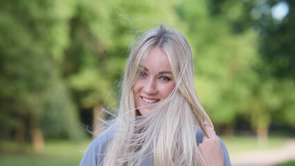 A cheerful young woman delights in nature with her flowing hair, radiating pure happiness and...