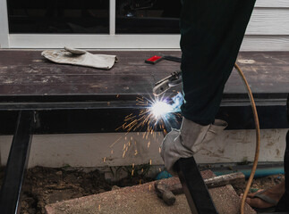 Worker welder performs Arc welding process of metal structures.