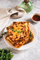 Crispy pizza with bacon, cheese and ketchup on toast on a plate on the table vertical view
