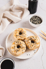 Rice donuts with meat and sesame seeds on a plate on the table vertical view