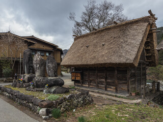 Ancient Stone Statues by Thatched Hut