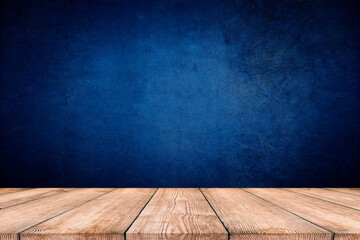 Dark blue background, with empty wooden table, dark wall background. Empty workplace in front of abstract package.