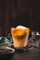 Delicious sweet affogato coffee with creamy ice cream in a cup on the table vertical view