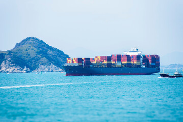 Cargo container ship sailing along of South Korean coast on her way out from container terminal in...